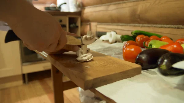 Руки шеф-повара. Человек в белой одежде режет овощи. Свежий перец, помидор, огурец и зеленый на заднем плане — стоковое фото