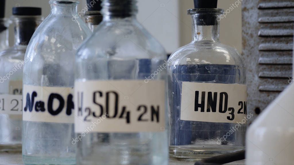 Bottles of solutions stored on shelf in laboratory. Bottles with