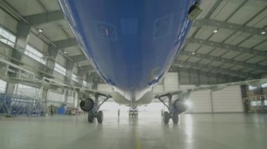 Uçak hangar, uçak ve ışık--dan pencere eşiği arka görünüm. Büyük yolcu uçağı hangara bir servis bakım