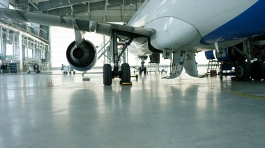 Uçak hangar, uçak ve ışık--dan pencere eşiği arka görünüm. İş jet Uçak hangarında olduğunu. Uçağın arkasında yol açın ve tüm uçak hangarı içinde