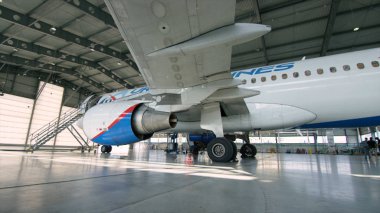 Uçak hangar, uçak ve ışık--dan pencere eşiği arka görünüm. İş jet Uçak hangarında olduğunu. Uçağın arkasında yol açın ve tüm uçak hangarı içinde