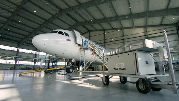 Uçak hangar, uçak ve ışık--dan pencere eşiği arka görünüm. İş jet Uçak hangarında olduğunu. Uçağın arkasında yol açın ve tüm uçak hangarı içinde — Stok fotoğraf