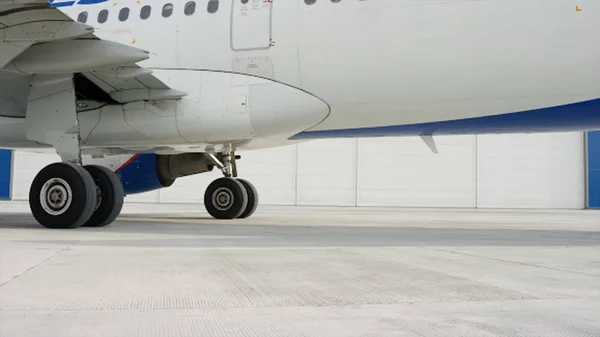 Hangar yakınlarında uçak Parkı. Güneşli bir günde havaalanında pistte büyük beyaz yolcu jet uçağı. Havaalanına park edilen uçak yatılı yolcular için bekliyor — Stok fotoğraf