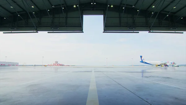 Tekercs, vagy a repülőtéren hangar ajtó redőny. Shutter ajtó vagy Redőnykapu és beton padló belső üzemi épület, ipari háttér. hullámosított fém ajtók kereskedelmi épület — Stock Fotó