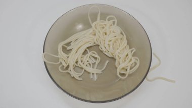 Ahşap masa üzerinde üstten görünüm beyaz porselen tabak içinde mantar Krema soslu makarna. Spagetti makarna domates ve maydanoz ahşap masa üzerinde. Üstten Görünüm