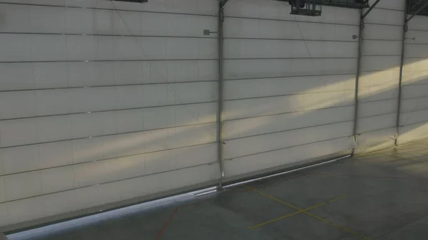 Arplane hangar with doors shut. Shutter or roller door in airport hangar opens and plane background — Stock Photo, Image