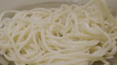 İtalyan makarna spagetti pesto sos ve fesleğen yaprak yakın çekim. Spagetti makarna sarmal iplikçiklerinin closeup arka plan. İtalyan pasta portre. Makarna. Seçici odak.