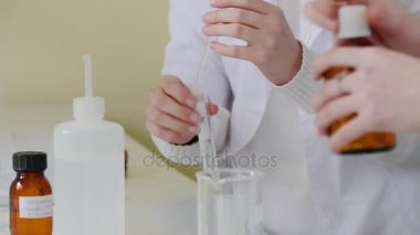 Tıbbi işçi sıvıları test damlalık ile. Öğrenci laboratuvar damarları deneylerde kullanılan. Laboratuvarda işe