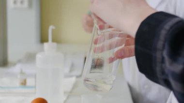 İki genç kadın bilim laboratuarında deneyler yapıyor. Kadın profesyonel ekipmanları tarafından çevrili laboratuvarda deneyler yapıyor