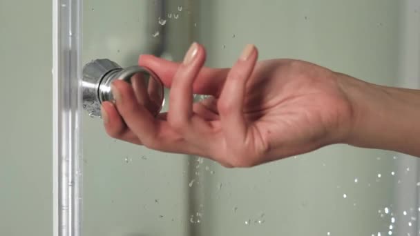 Γυναικείο χέρι ανοίγει την πόρτα στην καμπίνα ντους. Γυναίκα λαβή λαβή μπάνιο καμπίνα με το δεξί χέρι. Λεπτομέρεια από μια μοντέρνα γυάλινη καμπίνα ντους. Ντους — Αρχείο Βίντεο