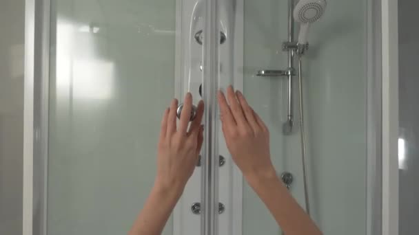 Las manos de las mujeres abre la puerta en la ducha. Cabina de ducha moderna con un gran número de dispositivos — Vídeo de stock