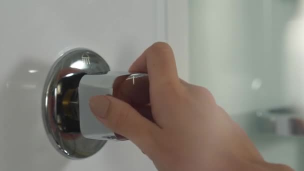 Moderne douchecabine met hydromassage. Dames hand draait het water op in de douche — Stockvideo