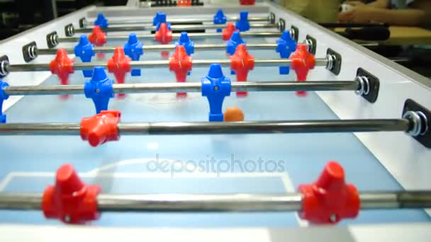 Pateador de partidos de futbol de mesa. Juego de futbolín, mesa de fútbol con jugadores rojos y azules. Jóvenes amigos jugando futbolín juntos en interiores — Vídeos de Stock