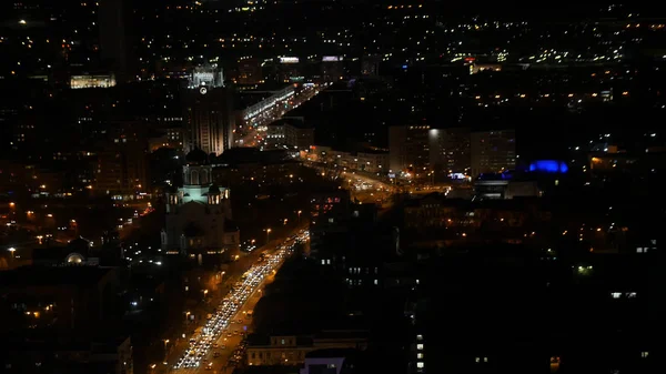 Sentieri luminosi sull'edificio moderno. La vita della città di notte con il traffico. Concetto di vita notturna — Foto Stock