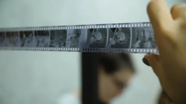 Photographer looking on negative film. Done work inspecting. Old fashioned photographing. Photographer inspecting negative film — Stock Photo, Image