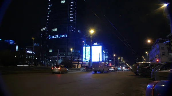 Ekaterinburg, Oroszország - 2017 október: Idő telik el este városi forgalomban. A forgalom a metszéspontok, amelyek a felhőkarcoló az éjszakában — Stock Fotó