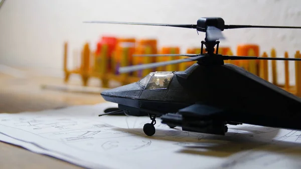 Helicóptero militar de juguete sobre mesa de madera. Pequeño juguete modelo hobby del helicóptero del ejército en la mesa. Helicóptero de juguete sobre la mesa —  Fotos de Stock