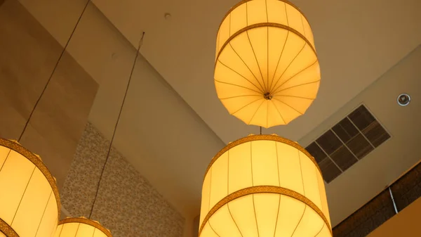 Бумажные фонари свисают с потолка. Китайский бумажный фонарь, свисающий с потолка. Желтый китайский бумажный фонарь висит на цепочке . — стоковое фото