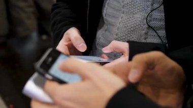 Yakın çekim akıllı iki genç adamın elinde. Yeni nesil bir kafede kapatın. İletişim kavramı. Çift dijital araçları kullanma online alışveriş, sohbet, bloglama, internet'te gezinmek için