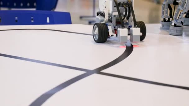 Nuovo progetto robot. Guidare sopra il nastro nero. Auto controllo con rilevatore di percorso. Robot per veicoli elettrici su ruote durante la gara — Video Stock
