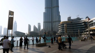 Dubai, Birleşik Arap Emirlikleri - 25 Mayıs, 2017: insanlar yürüyüş vasıl kare Uluslararası Dubai Kongre ve Sergi Sarayı kule geçmiş. Uluslararası Dubai Kongre ve Sergi Sarayı kulesi. Bu gökdelen 828 m. ölçülerinde en yüksek insan yapımı dünyada yapıdır.