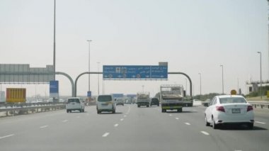 Birleşik Arap Emirlikleri, Dubai - Ekim 2017: arabayı bir görünümü ile Dubai arabayla seyahat adam. Arabanın iç Dubai, sokaklarda adam sıcak bir arabanın direksiyonuna görüntüleyin.