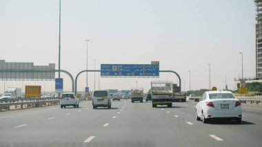 Birleşik Arap Emirlikleri, Dubai - Ekim 2017: arabayı bir görünümü ile Dubai arabayla seyahat adam. Arabanın iç Dubai, sokaklarda adam sıcak bir arabanın direksiyonuna görüntüleyin. 