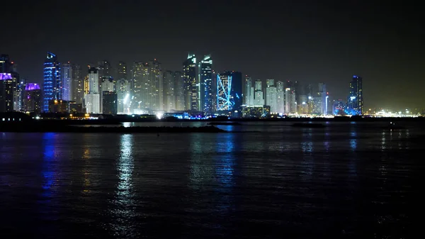 Dubai centrum nachts weerspiegeld in water. Stad bij nacht, panoramische scène van de binnenstad tot uiting in water, Dubai. Dubai centrum at night met reflectie in water, moderne ontwerp van new city — Stockfoto