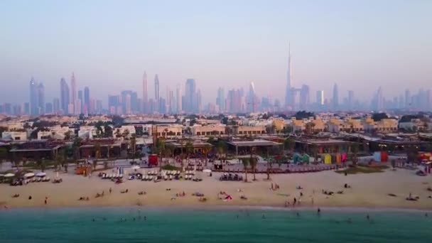 Gyönyörű légifelvételek strand fentről sunrise és a város futurisztikus városképeket épületek és infrastruktúra. Dubai, Egyesült Arab Emírségek. Felülnézet Dubai napkeltekor. — Stock videók