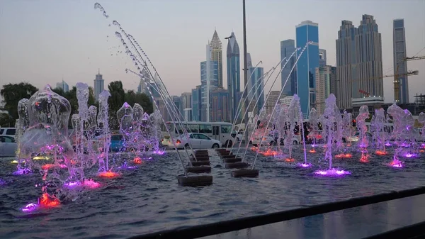 Many small splashing dancing fountains in summer Dubai park. Outdoor small fountains in order to refresh themselves in the summer — Stock Photo, Image