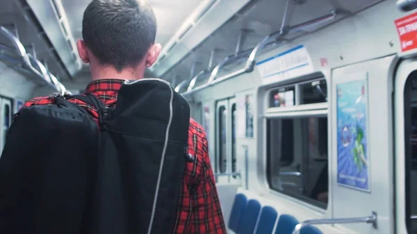 Вид сзади на человека в вагоне метро, каюте. Крупный план молодого человека, путешествующего пассажиром в вагоне . — стоковое фото