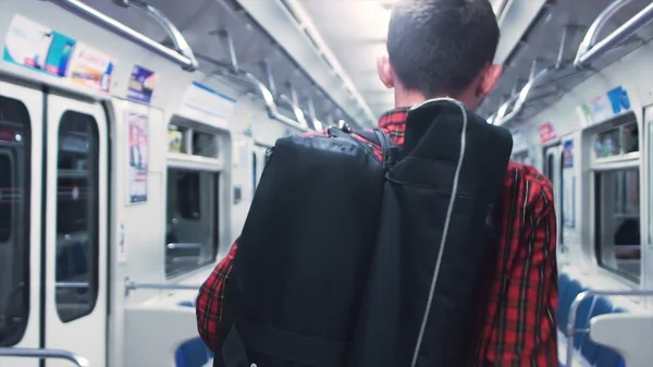 Vista trasera del hombre en el vagón del metro, cabina. Primer plano de un joven viajando como pasajero en un vagón de tren . — Foto de Stock