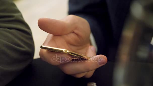 Tenendo il lingotto d'oro in mano da vicino. Uomo che tiene in mano un piccolo lingotto d'oro. Un'oncia d'oro. Oro in mano umana . — Video Stock