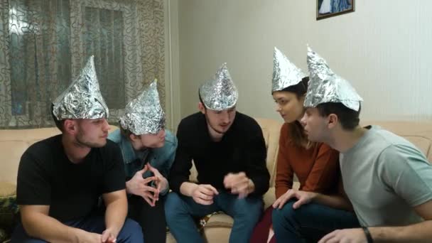 Amigos en papel aluminio en la cabeza de la casa. Reunión de amigos para escuchar sus ideas de civilizaciones extraterrestres — Vídeos de Stock