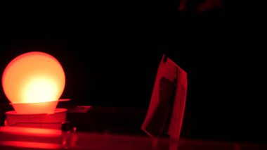 Adanmış ve gayretli fotoğrafçı, stop banyo bir karanlık odada bir taze basılı fotoğraf kaldırılıyor. Karanlık bir odada fotoğraf basma, taze maruz sayfası geliştirme içinde koyarak fotoğrafçı