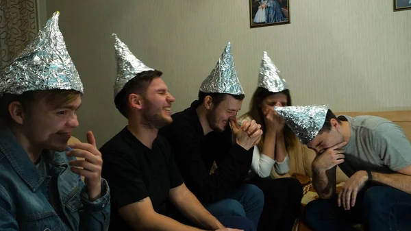 Freunde lachen über ihre Ansichten, haben sie auf dem Kopf Folie, um ihre Gedanken vor Ufo zu schützen — Stockfoto