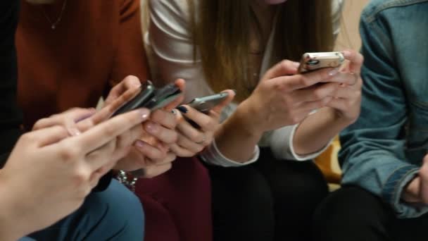 Primer plano de amigos charlando en el teléfono móvil en red. Grupo de amigos están utilizando gadgets durante el tiempo de recreación en casa. Amigos sentados y charlando en el primer plano del teléfono — Vídeo de stock