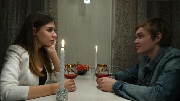 Mladý pár se svým přítelem na romantickou večeři a pití vína společně doma. Dívka s klukem na romantické rande doma — Stock video