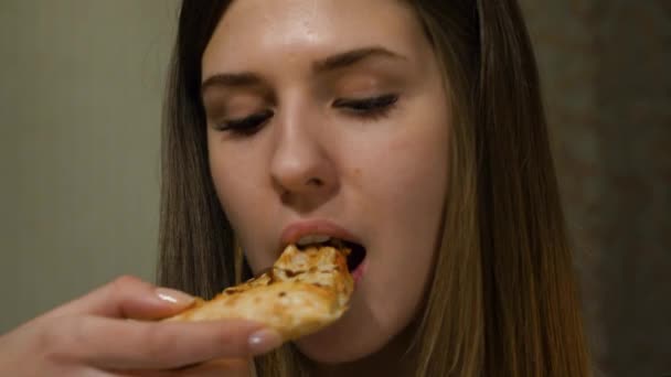 Vacker kvinna äter pizza. Njuter av måltiden. Italiensk mat hemma. Porträtt av en vacker kvinna som hon äter en pizza — Stockvideo