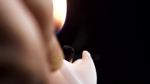 Detalle de cerca de la llama de la vela encendida de cera blanca y mecha sobre fondo negro aislado. andle luces macro. primer plano de vela ardiente aislado sobre fondo negro una llama en la noche macro brillante en — Vídeo de stock