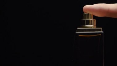 Koku lüks şişe içeriği karanlık püskürtme ağır çekimde. Siyah arka plan üzerine parfüm şişe sprey. Köln bir siyah arka plan üzerine püskürtme. kadar parfüm kullanma yakışıklı genç iş adamı kaybetmek veya