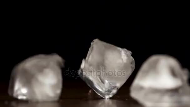 Cubes de glace tombant et rebondissant sur fond noir au ralenti. Gouttes de glace sur fond noir — Video