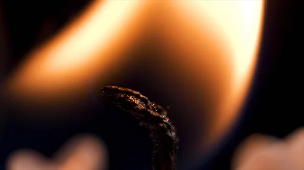 Détail rapproché de la flamme et de la mèche de la bougie allumée à la cire blanche sur fond noir isolé. andle illumine macro. gros plan de la bougie brûlante isolé sur fond noir une flamme la nuit macro brillamment dans — Photo