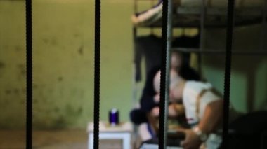 Mahkumlar giyen hapishane üniforması ile alüminyum yemekleri bir hapishane hücresinde başucundaki yakınındaki yatakta yatarken düşünce kaybetti. Mahkûmlar parmaklıklar arkasında yatağın üstüne oturuyor