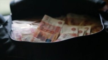 Rus para birimi cinsinden para dolu siyah bir çanta. Konu yolsuzluk ve Rusya'da mali suçlar cezasızlık kavramı. Rus parayı çantaya