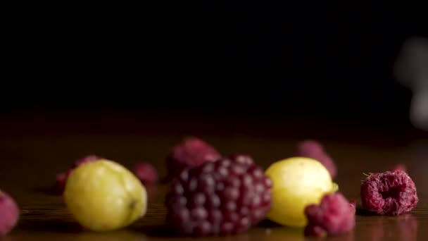 Man hands takes Fresh berries. Blueberries, raspberries, gooseberries, cranberries on the table on a black background, healthy food concept — Stock Video