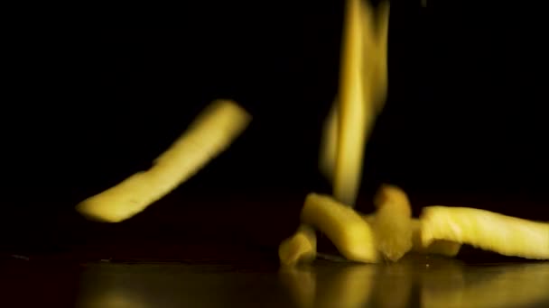 Pommes auf schwarzem Hintergrund. bereit köstliche Pommes frites fallen auf einem schwarzen Hintergrund, das Konzept der Fast Food — Stockvideo