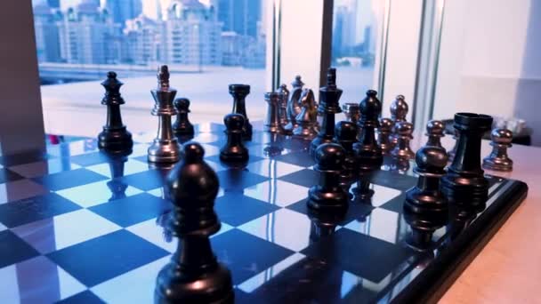 窓の近くの市松模様。ゴールド チェス女王の形で賞の置物は、ウィンドウの前に立ちます。ビジネスのアイデアの競争と戦略のアイデア チェス ボード ゲーム コンセプト — ストック動画