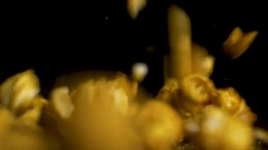 Siyah arka plan üzerine düşen patlamış mısır. Masada, patlamış mısır siyah arka plan, ağır çekim üzerine eğilerek