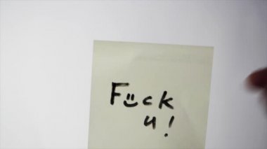 Yazıt siktir git etiketinde. Not cam üzerinde bir kağıt parçası fuck you, saldırganlık kavramı